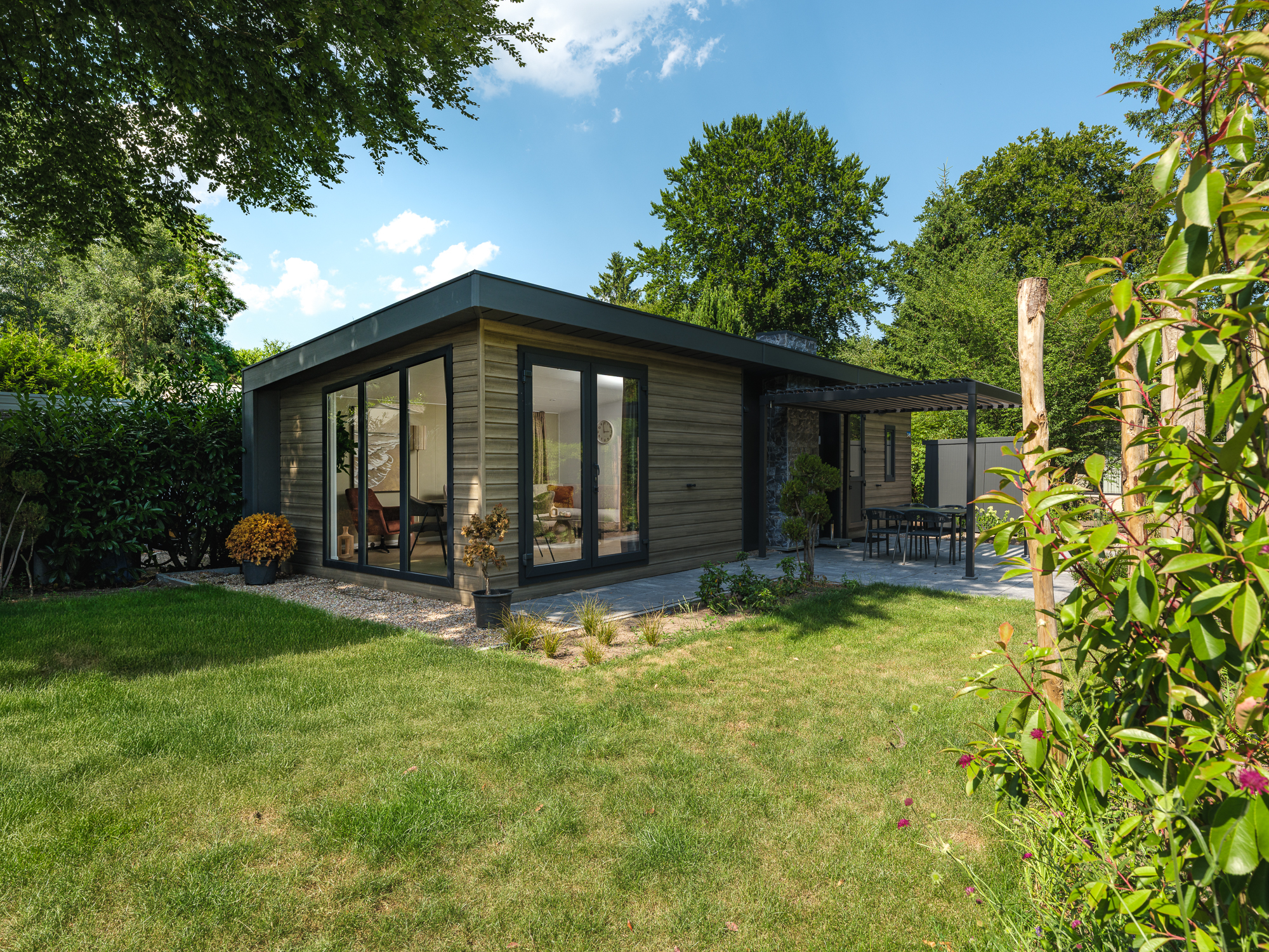 Geniet van een vakantiewoning in de bosrijke natuur van de Veluwe, compleet met moderne voorzieningen en een stijlvolle pergola voor optimaal comfort.